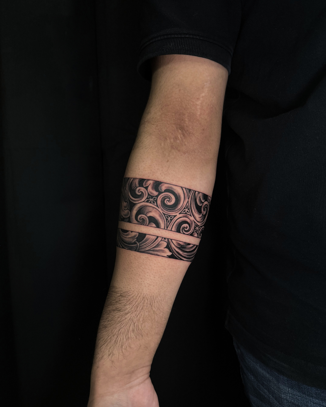 Intricate black and grey armband with swirls