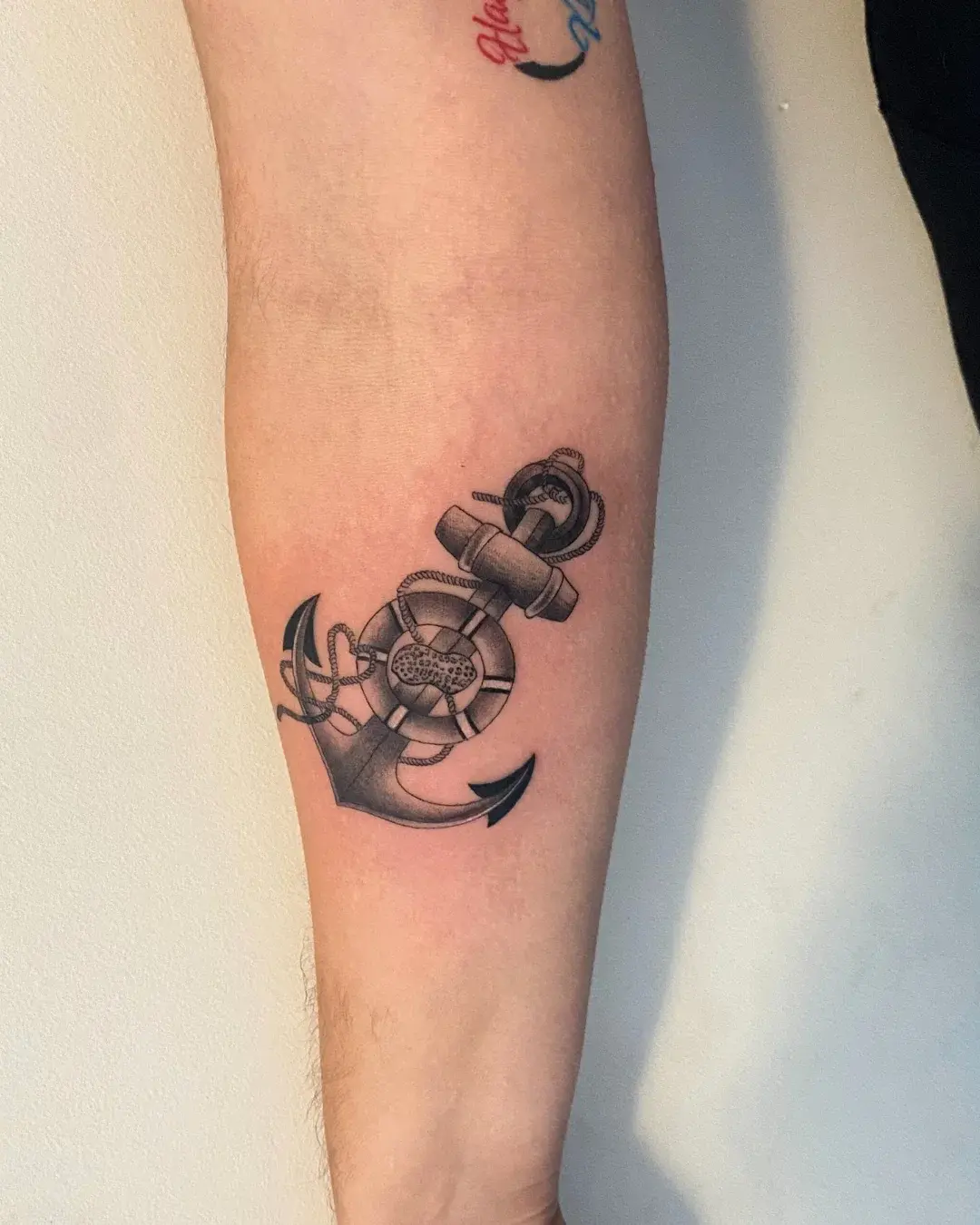 Large black and grey clock with Roman numerals and a detailed rose on the forearm