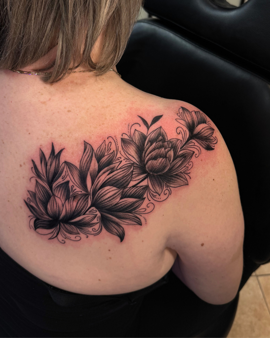 Black and grey forearm tattoo of a Greek statue head, likely Zeus or Poseidon