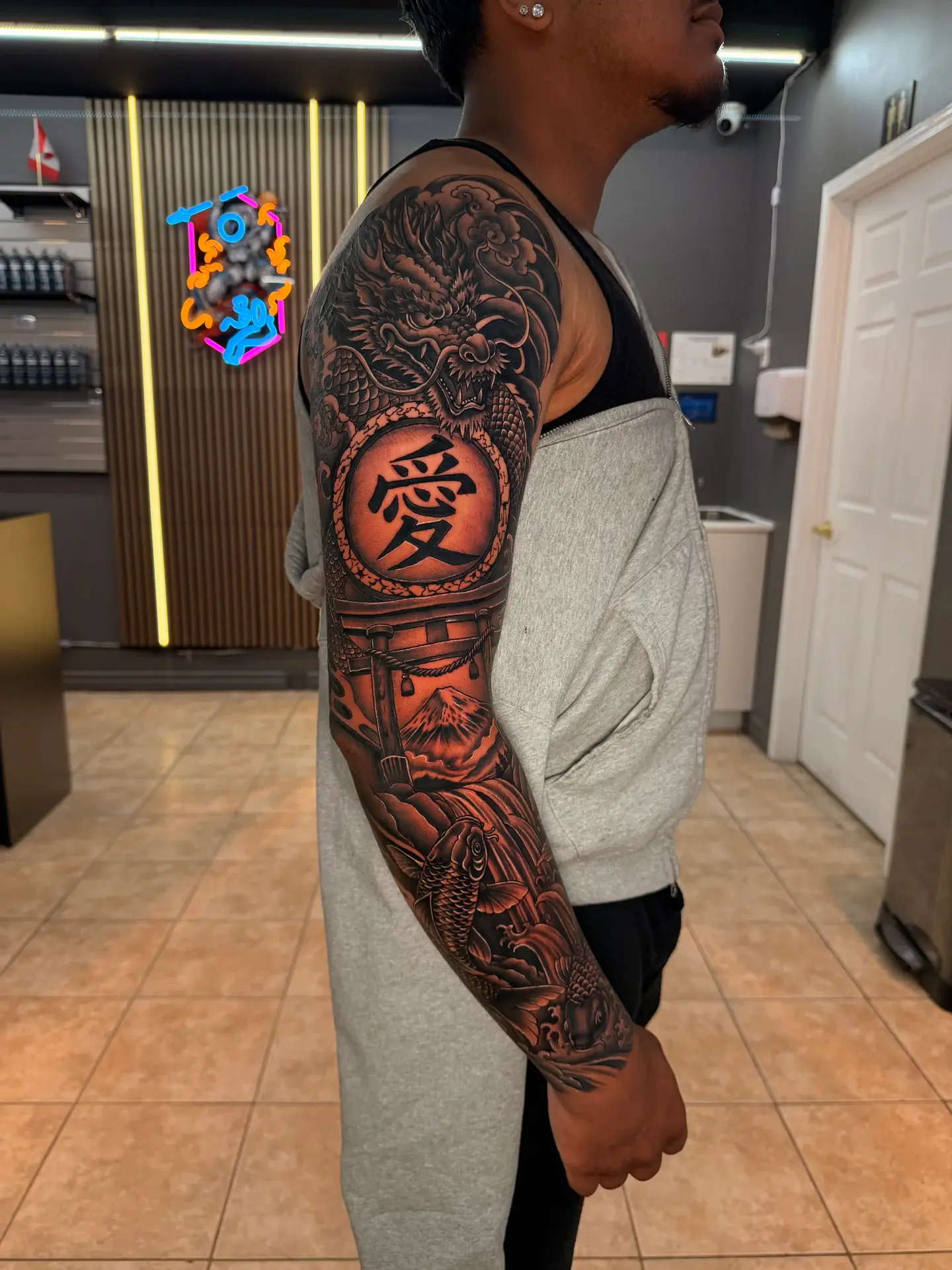 Black and grey full Japanese sleeve with dragon, kanji emblem, torii gate, and koi
